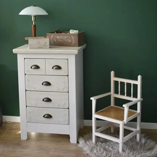 Chaise enfant en bois peinte couleur Beige rosé à côté d'un meuble à tiroirs repeint en Blanc