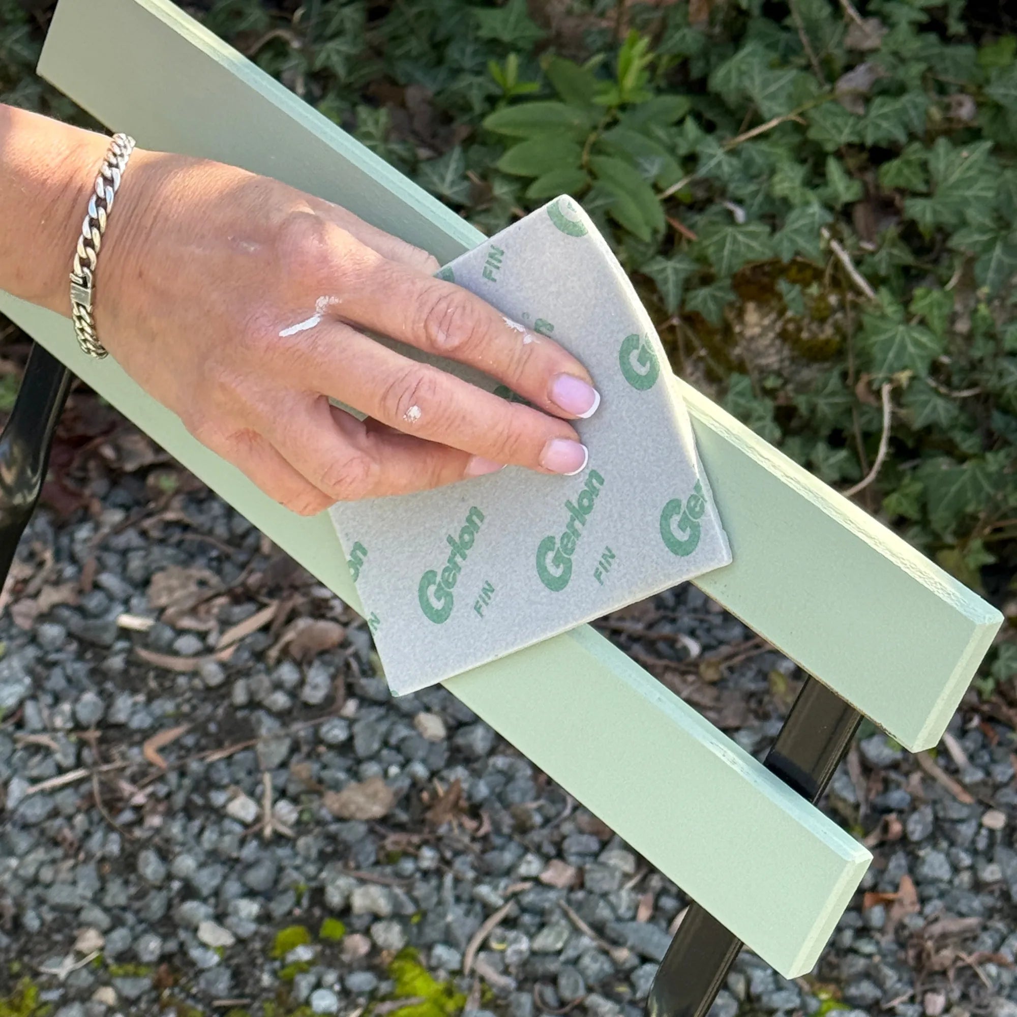 Égrainage d'une chaise teinte fenouil pour deuxième couche de peinture.
